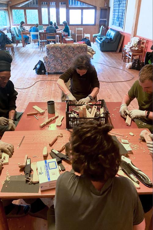 Un gruppo di persone sedute ad un tavolo durante il corso di intaglio in Lombardia vicino al Lago di Garda