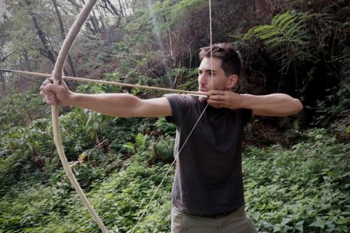 Un ragazzo scaglia una freccia dopo aver costruito il suo arco primitivo durante il corso vicino al Lago di Garda in Lombardia