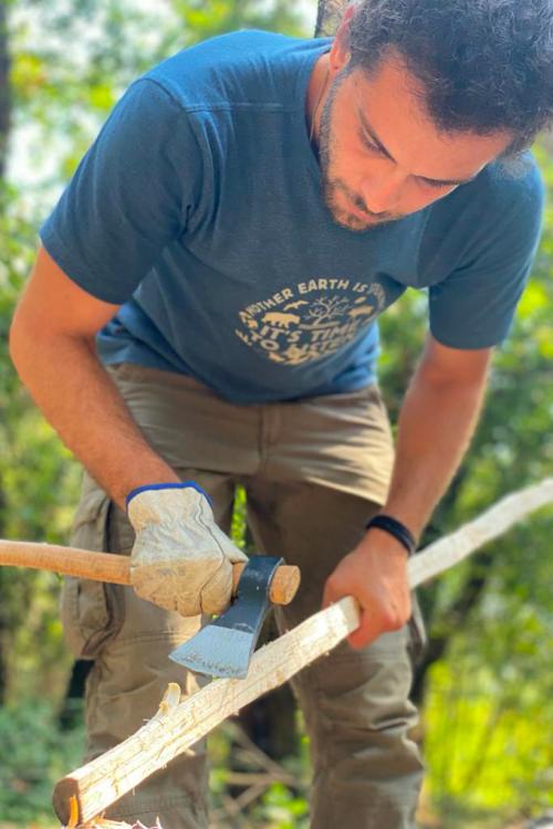 Un ragazzo usa una accetta per creare un arco durante il corso sul Lago di Garda in Lombardia