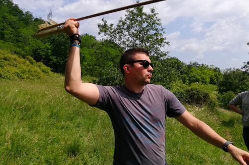 Un uomo che impara a lanciare una freccia durante il corso per imparare a costruire un arco primitivo vicino al Lago di Garda in Lombardia