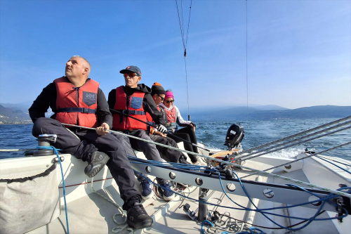 Delle persone su una barca a vela durante il corso pratico a San Felice del Benaco sul Lago di Garda in Lombardia