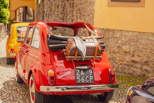 3 Fiat 500 d'epoca nei vicoli stretti di un borgo sul Lago di Como in Lombardia durante un tour panoramico guidato