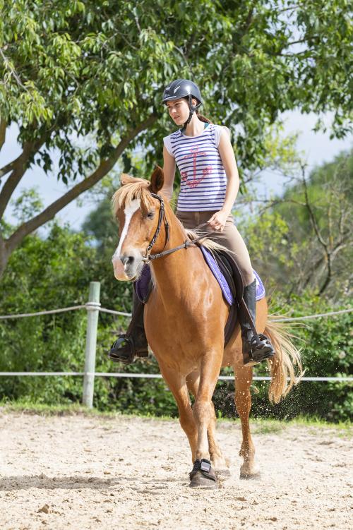 Una ragazza in sella impara il cambio di direzione durante il corso di equitazione a Rivolta d'Adda in Lombardia