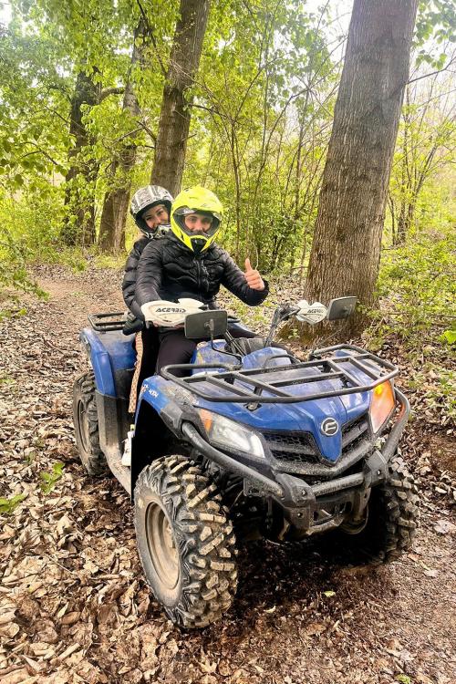 Una coppia di ragazzi si diverte in sella ad un quad su strade sterrate nei boschi vicino a Sondrio in Valtellina in Lombardia