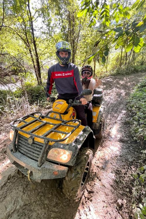 Una coppia di ragazzi si diverte a fare fuori strada su un quad durante un tour adrenalinico in Lombardia vicino Sondrio in Valtellina