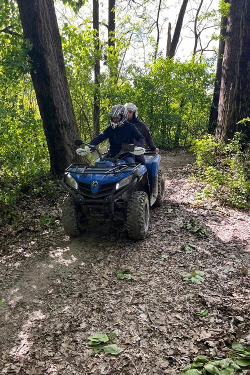 Due dipendenti di una azienda durante un tour panoramico in quad si divertono e ammirano il paesaggio selvaggio della Valtellina vicino a Sondrio in Lombardia