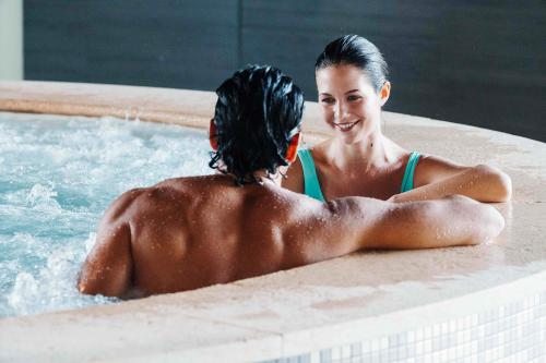 Un uomo e una donna parlano dentro la vasca idromassaggio delle terme di Monticello vicino al Lago di Como in Lombardia