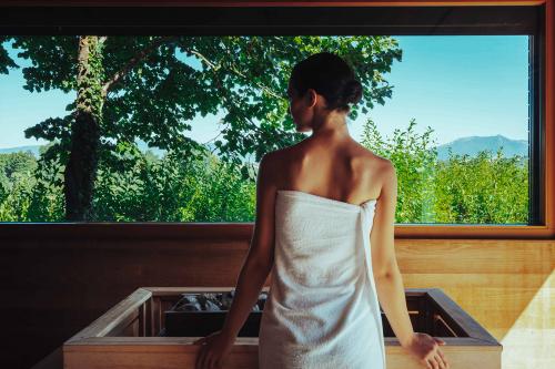 Una ragazza nella sauna di Monticello in Lombardia poco distante da Lecco ammira il paesaggio dalla finestra