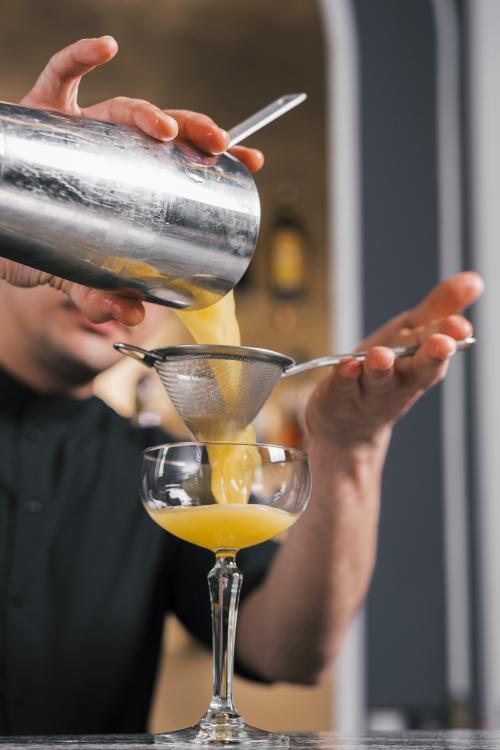 Bar tender che insegna come creare il cocktail perfetto durante il team building aziendale a Milano in Lombardia
