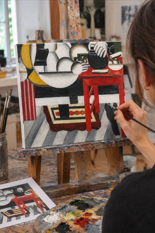 Ragazza che dipinge una parte di un dipinto durante il team building creativo in Lombardia sul Lago di Como a Lecco con artista